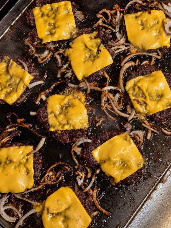 Oklahoma smash patties and cheddar on the griddle