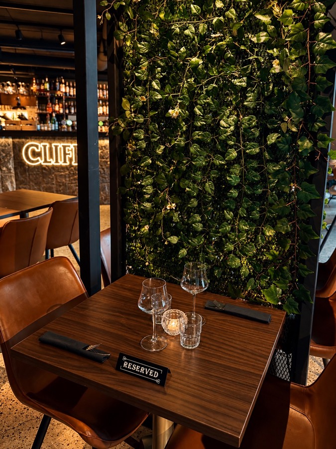 A set table beside the green wall at CLIFF