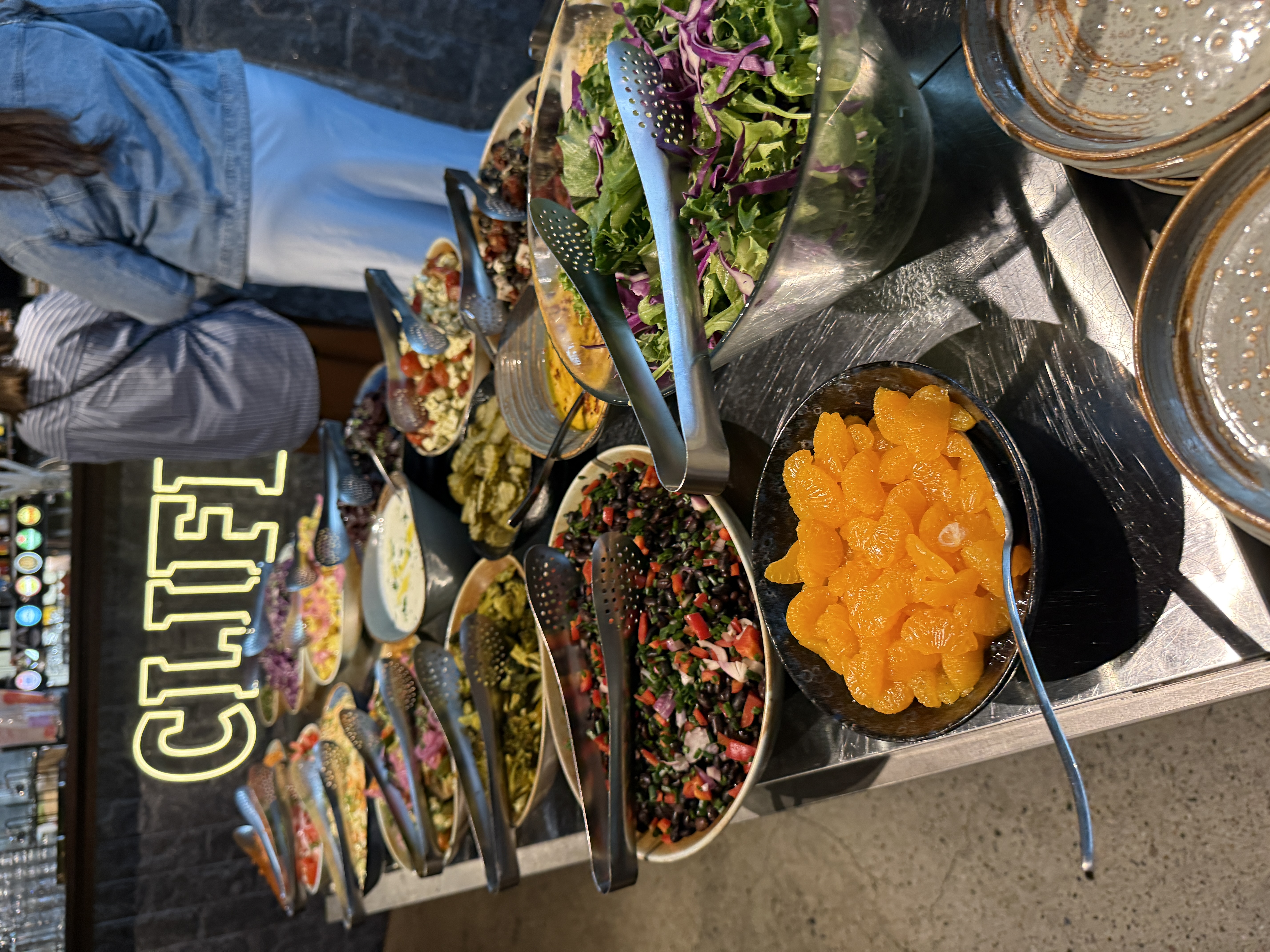 The Cliff salad bar with a generous selection of salads and the illuminated CLIFF sign.
